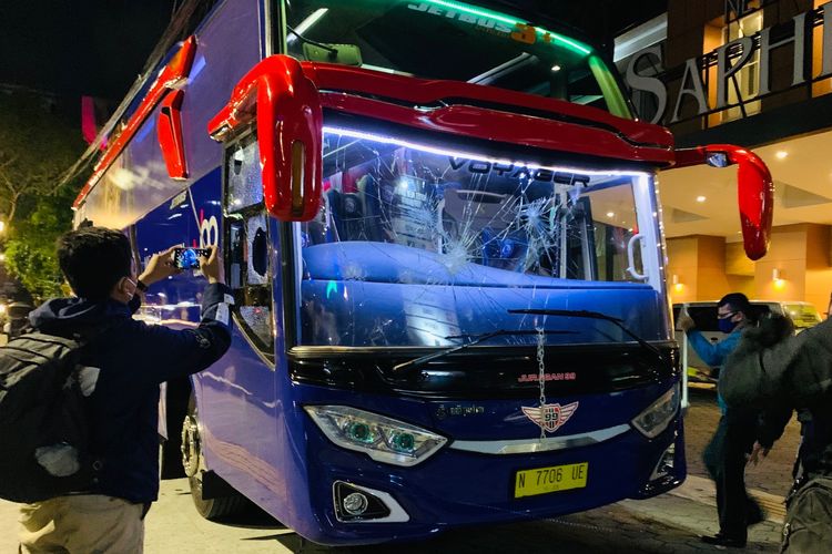 Seorang pria mendokumentasikan bus Arema FC yang baru saja diserang segerombolan orang tidak dikenal di depan Hotel New Saphir Yogyakarta, Rabu (20/10/2021) malam.
