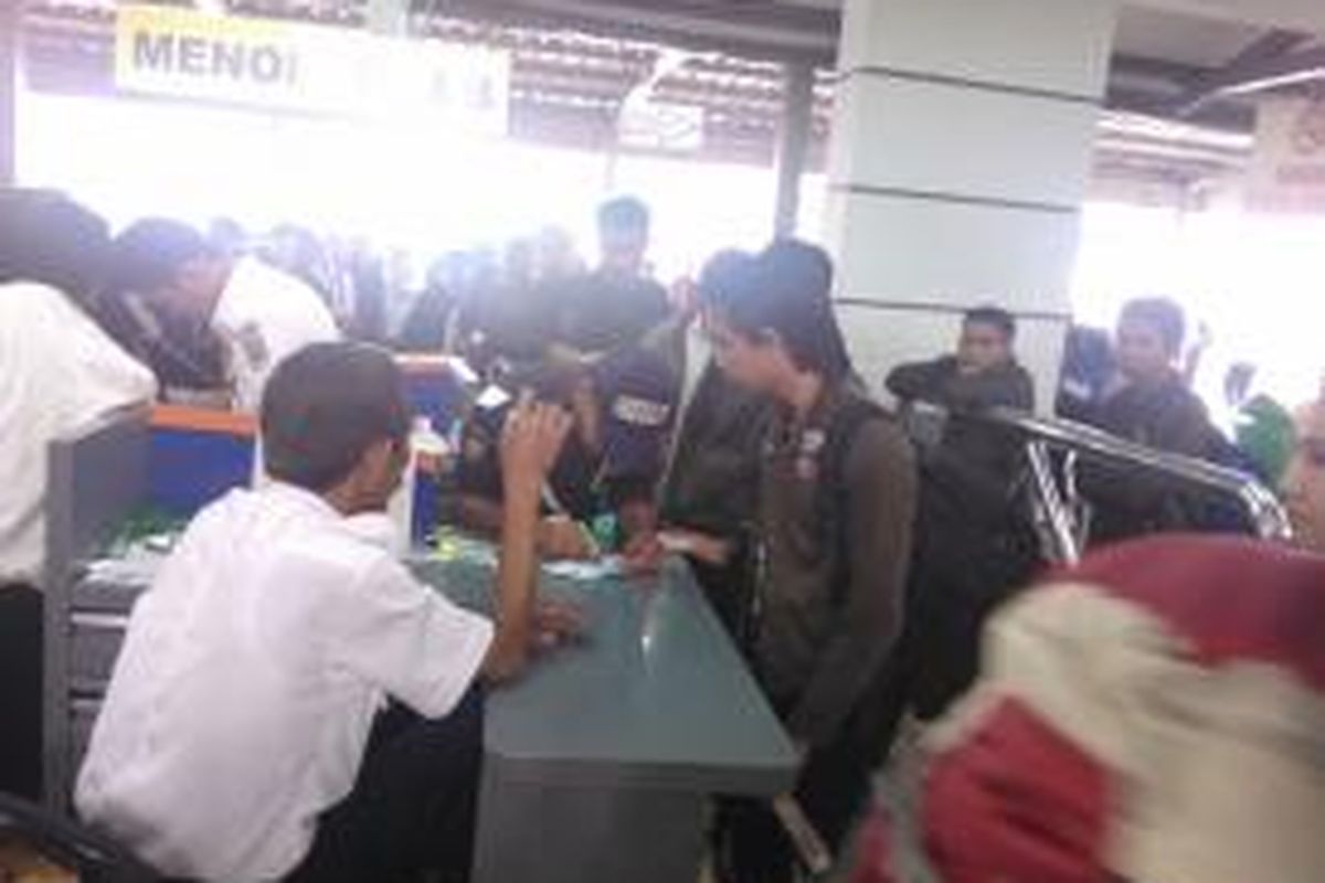 Pemeriksaan tiket di Stasiun Pasar Senen, Jakarta Pusat, yang dilakukan secara manual, Rabu (23/7/2014). Seorang petugas mencocokkan tolet dan kartu identitas, kemudian memberi warna nama di tiket, sementara satu orang petugas lain memberi stempel pada tiket yang sudah bertanda.