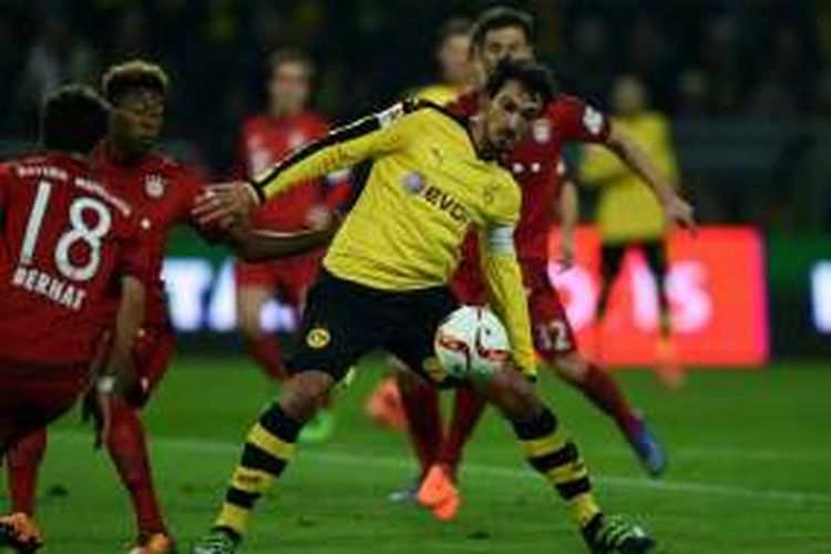 Bek Borussia Dortmund, Matt Hummels, berupaya mempertahankan bola dari para pemain Bayern Muenchen, pada laga Bundesliga di Stadion Signal Iduna Park, Sabtu (5/3/2016) waktu setempat.