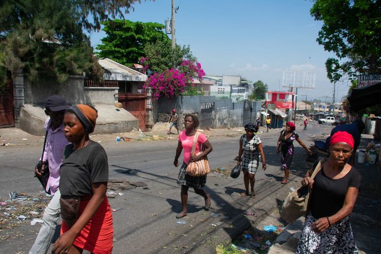Para pedagang meninggalkan daerah tersebut setelah terdengar suara tembakan di Port-au-Prince, Haiti, pada 20 Maret 2024.