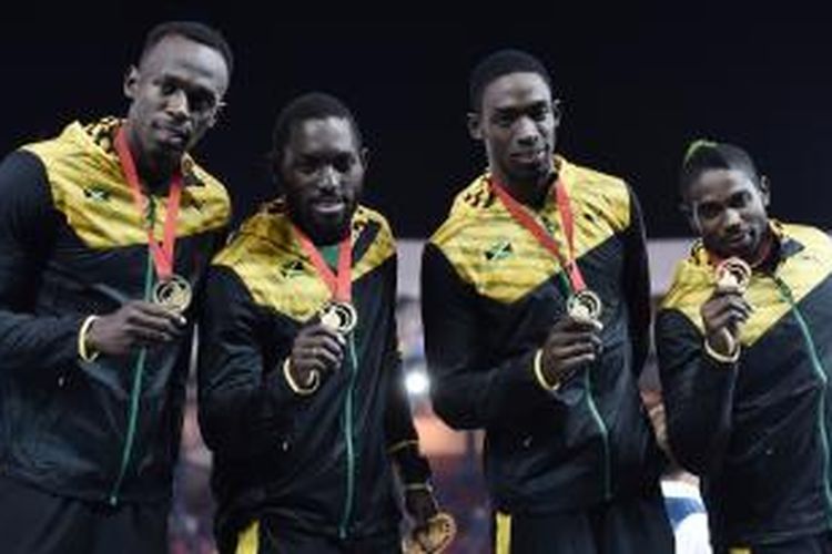 Pelari Jamaika, Usain Bolt (kiri), berpose bersama pelari lainnya, Nickel Ashmeade, Kemar Bailey-Cole, dan Jason Livermore, sambil memamerkan medali emas yang mereka dapatkan setelah menjuarai nomor lari estafet 4 x 100 meter pada Commonwealth Games di Hampden Park, Glasgow, Skotlandia, Sabtu (2/8/2014).