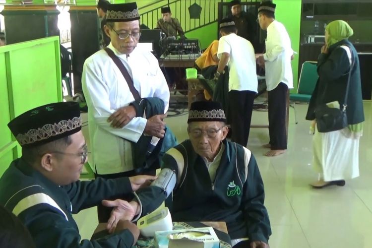 Petugas memeriksa kesehatan tensi darah Mbah Harjo Mislan, calon jamaah haji tertua se Indonesia.asal Kabupatrn Ponorogo, Jawa Timur. 