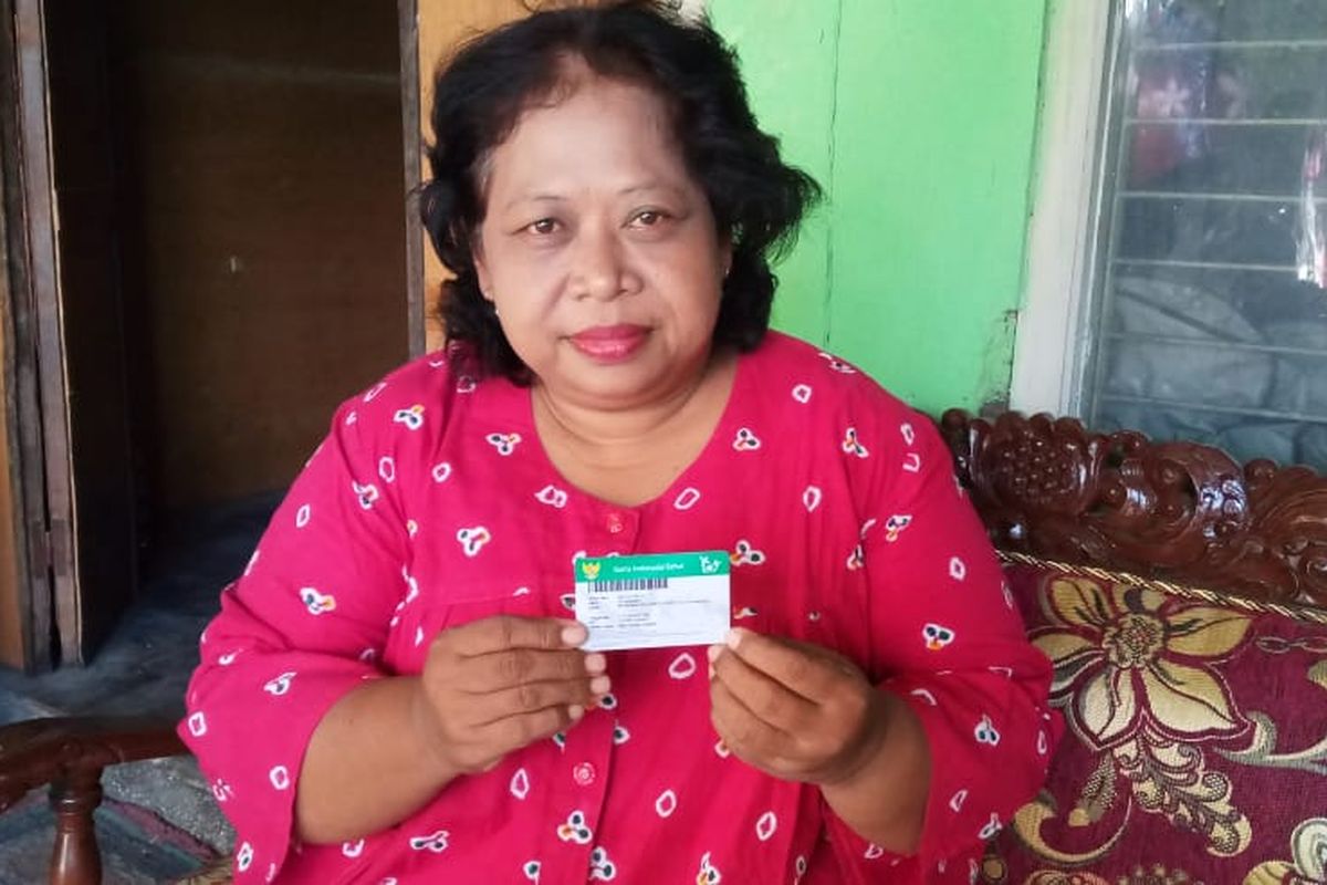 Ketua RW 028 Kelurahan/Kecamatan Jebres, Solo, Ida Nurwati, 55, menunjukkan kartu JKN-KIS miliknya di latar rumahnya, Selasa (14/7/2020). Berangkat dari pengalaman pribadi dan arahan dari Pemkot Solo, dia mengaku rutin menyosialisasikan program JKN-KIS kepada warga lain.