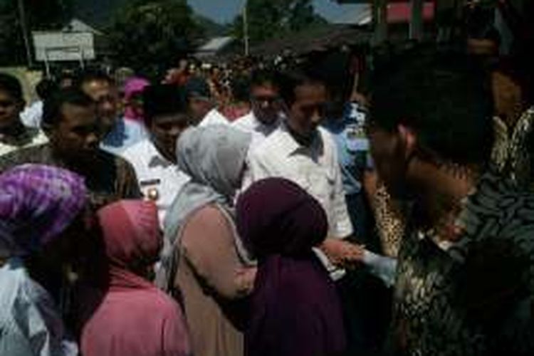 Presiden Joko Widodo didampingi Ibu Negara Iriana membagikan paket sembako dalam kunjungan kerja di Sumatera Barat, Selasa (5/7/2016).