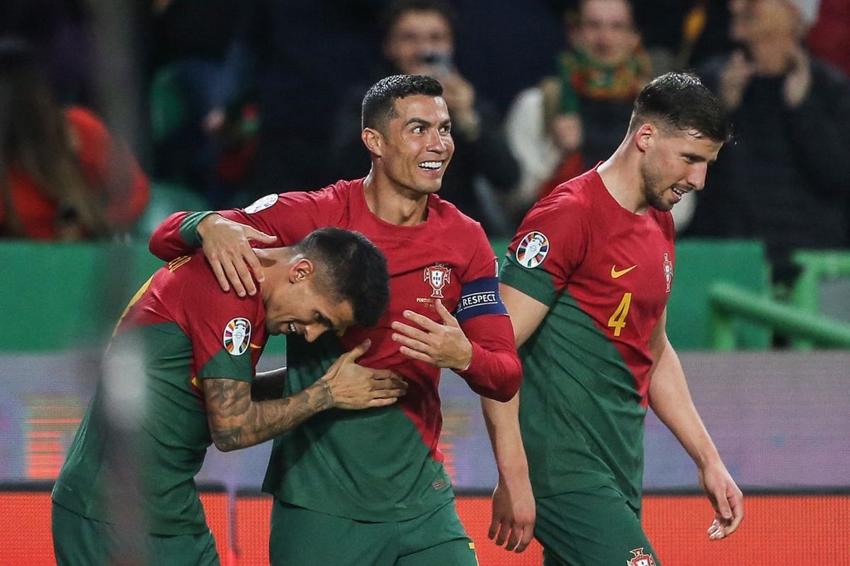 Cristiano Ronaldo (tengah) merayakan gol yang dicetak Joao Cancelo (kiri) dalam laga Kualifikasi Euro 2024 antara Portugal vs Liechtenstein di Stadion Jose Alvalade, Lisbon, 23 Maret 2023. Selanjutnya, Portugal bakal melawan Luksemburg dalam matchday kedua Kualifikasi Euro 2024. Laga Luksemburg vs Portugal bergulir di Stadion Luxembourg pada Senin (27/3/2023) mulai pukul 01.45 WIB. Artikel ini berisi prediksi Luksemburg vs Portugal. (Photo by CARLOS COSTA / AFP)