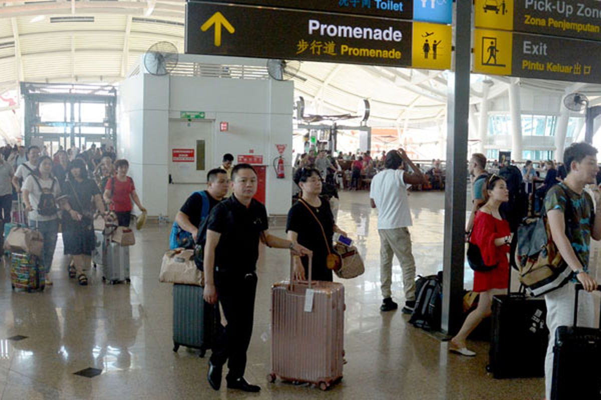 Sejumlah penumpang beristirahat menunggu jadwal penerbangan di Bandara Ngurah Rai, Bali, Jumat (29/6/2018). 