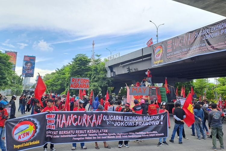 Massa buruh yang memakai kostum pakaian merah memadati kawasan Fly Over, Kota Makassar, Sulsel, Rabu (1/5/2024).