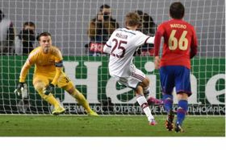 Gelandang Bayern Muenchen, Thomas Mueller (tengah), mencetak gol dari titik penalti setelah menaklukkan kiper CSKA Moscow, Igor Akinfeev (kiri), pada matchday kedua Grup E Liga Champions di Arena Khimki di Moscow, Selasa 30 September 2014.