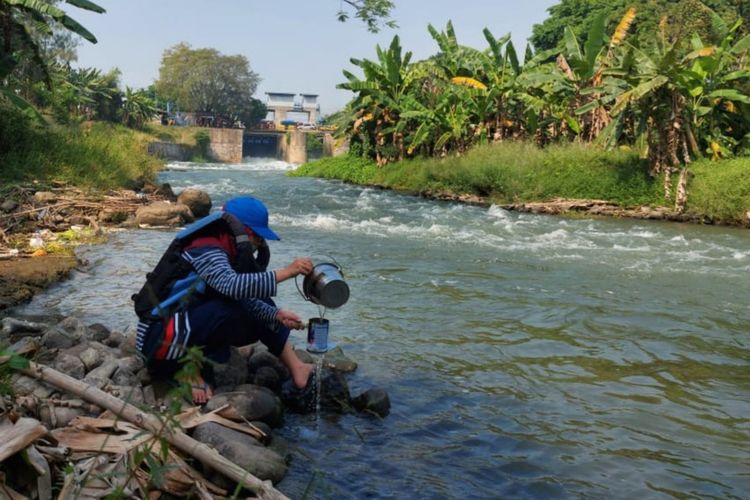 Mahasiswa peneliti memgambil sampel air sungai Kali Surabaya di Mlirip Mojokerto.