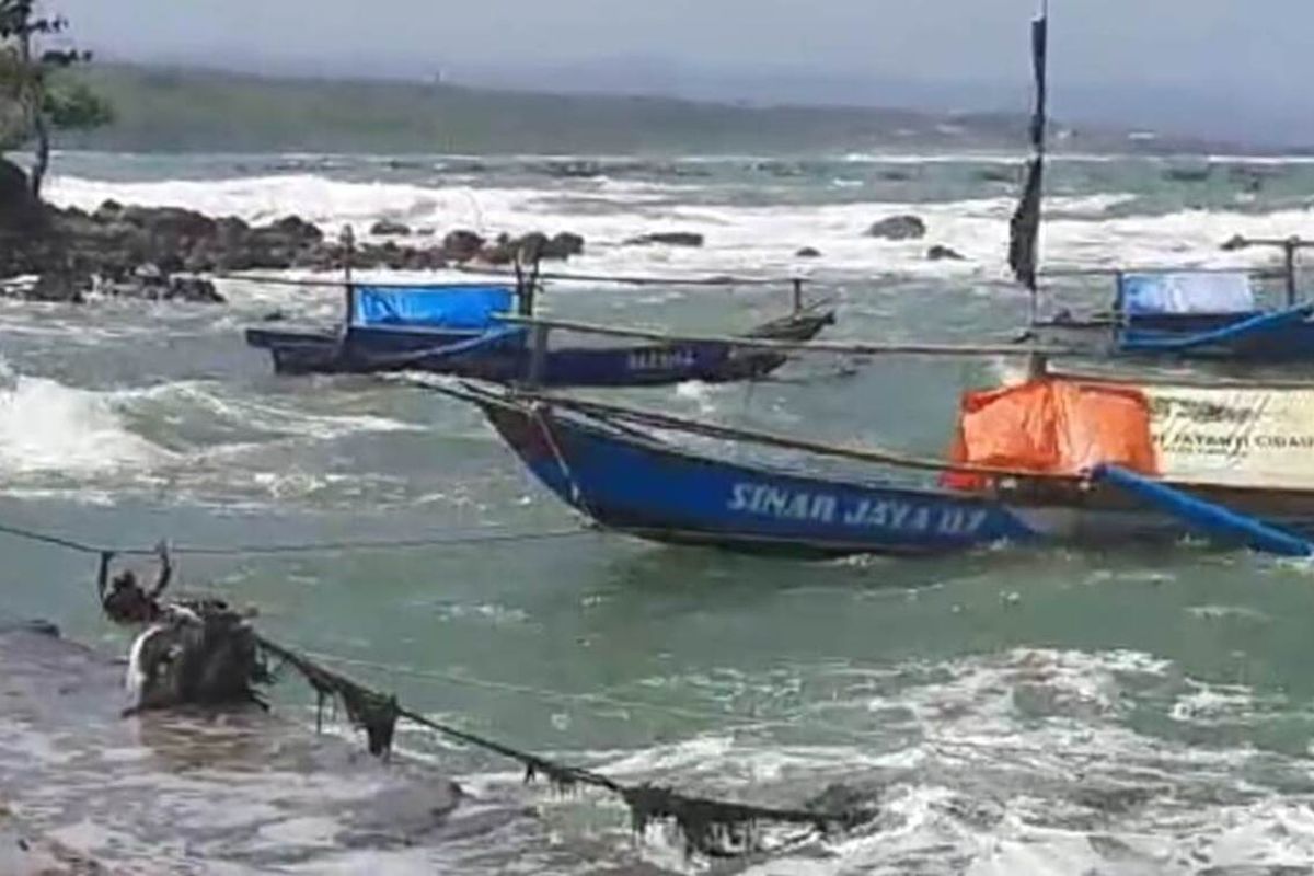 Seorang nelayan di Cianjur, Jawa Barat, tengah berupaya menambatkan perahunya di dermaga Jayanti, Cidaun, Sabtu (17/7/2021). Gelombang laut yang tinggi saat ini membuat nelayan urung melaut.