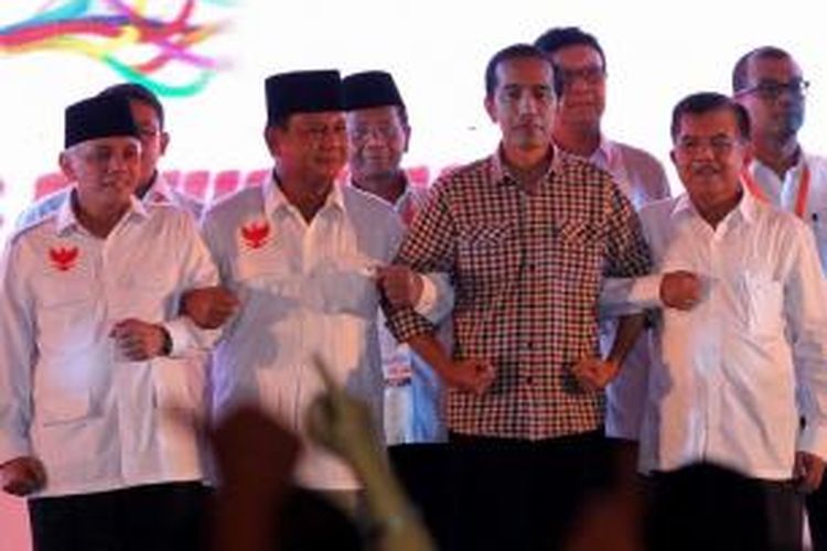 Calon presiden dan calon wakil presiden Prabowo Subianto-Hatta Rajasa bersama Joko Widodo-Jusuf Kalla saling berpegangan tangan usai mengikuti acara Deklarasi Piilpres Berintegritas dan Damai di Jakarta, Selasa (3/6/2014).