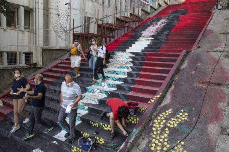 Orang-orang berjalan di tangga yang dilukis oleh mahasiswa dari Universitas Seni Rupa Mimar Sinan di Istanbul, Turki, pada 5 Oktober 2020.