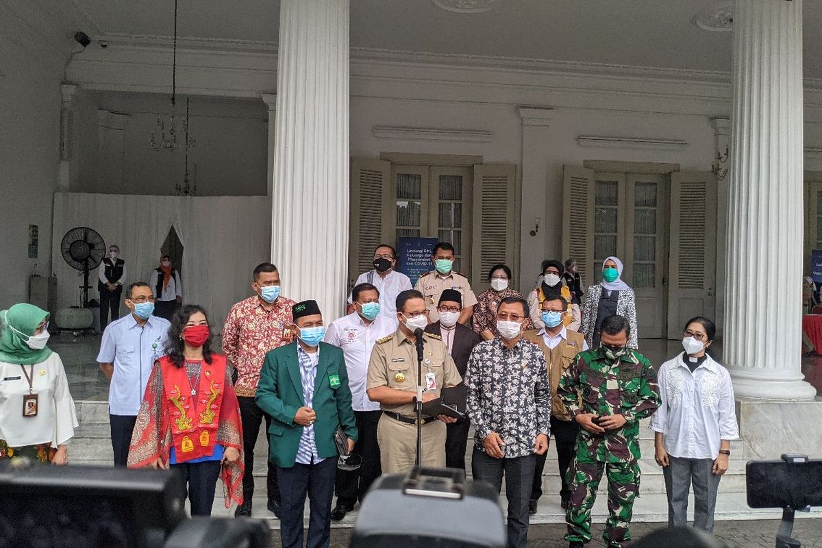 Gubernur DKI Jakarta Anies Baswedan (depan mikrofon) memberikan keterangan pers setelah acara pencanangan Covid-19 di Balai Kota DKI Jakarta, Jumat (15/1/2021)