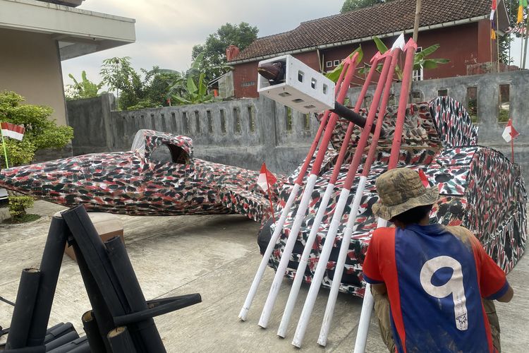 Salah seorang warga yang sedang mengecat replika kendaraan tempur di kampung Bojongkoneng Rw 03, Kelurahan Cibadak, Kecamatan Cibadak, Kabupaten Sukabumi. Senin (12/8/2024)
