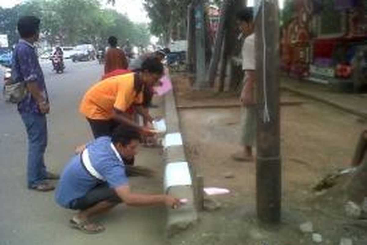 Sejumlah pedagang anggota Tim Paguyuban PKL Pasar Gembrong, Jakarta Timur, tengah mencat pembatas jalan di kawasan Jalan Basuki Rahmat, Jakarta Timur, Selasa (2/9/2013).