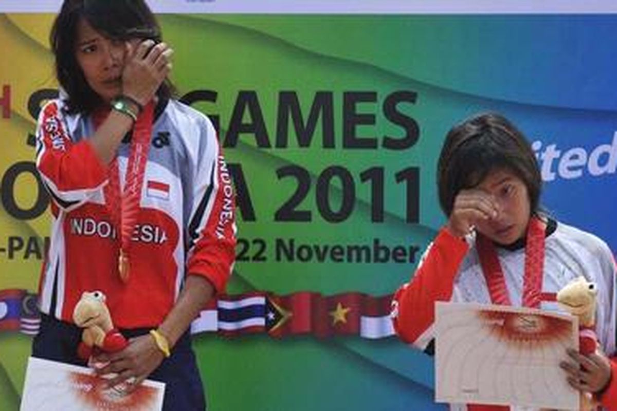 Pebalap sepeda Indonesia Risa Suseanty (tengah) dan Fitriyanti Riyanti (kanan) menitikkan air mata saat lagu Indonesia Raya dikumandangkan, pada upacar opemberian medali cabang balap sepeda nomor downhill SEA Games XXVI di Gunung Pancar, Bogor, Sabtu (12/11/2011).