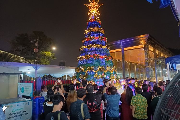 Jemaah mengambil gambar Pohon Natal di area Gereja Katedral Jakarta usai mengikuti Misa Malam Natal, Minggu (24/12/2023) malam.