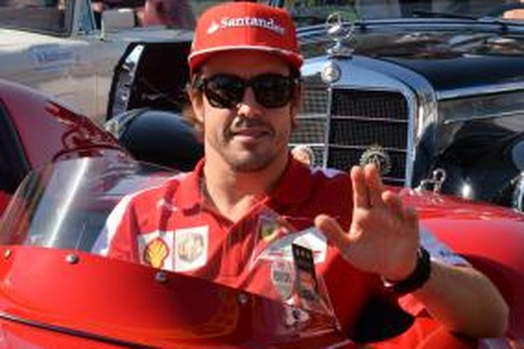 Pebalap Ferrari asal Spanyol, Fernando Alonso, melambaikan tangan saat parade sebelum GP Jepang dilaksanakan di Sirkuit Suzuka, MInggu (13/10/2013).