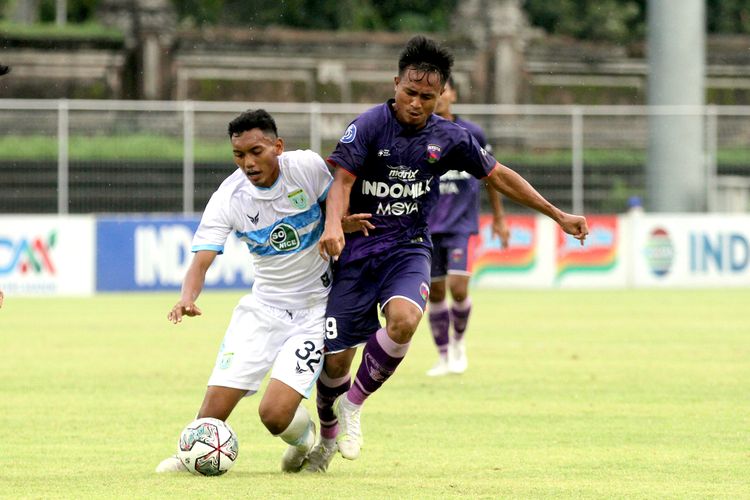 Pemain Persita Tangerang Ricki Ariansyah (kanan) berusaha merebut bola Pemain Persela Lamongan Syarif Wijianto (kiri) pada pertandingan pekan 19 Liga 1 2021-2022 yang berakhir dengan skor 3-0 di Stadion I Gusti Ngurah Rai Denpasar, Bali, Selasa (11/1/2021) sore.