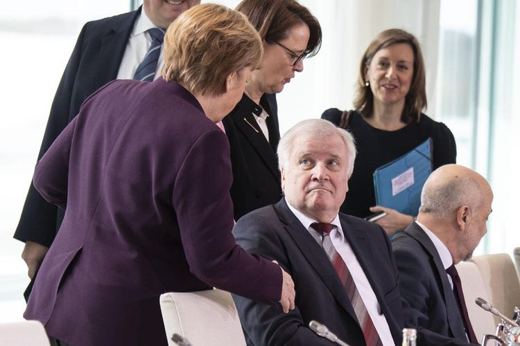 Kanselir Angela Merkel (kiri) menawarkan tangannya kepada Menteri Dalam Negeri, Horst Seehofer yang menolak jabatan tangan menghindari penularan virus corona saat kedatangannya pada KTT Integrasi ke-11 di kedutaan federal di Berlin, Jerman, 02 Maret 2020. EPA-EFE/OMER MESSINGER