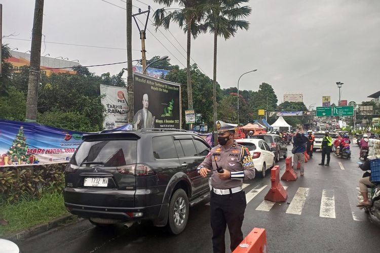 Sejumlah petugas kepolisian melakukan rekayasa lalu lintas di jalur Puncak Bogor, Jawa Barat, Jumat (30/12/2022).