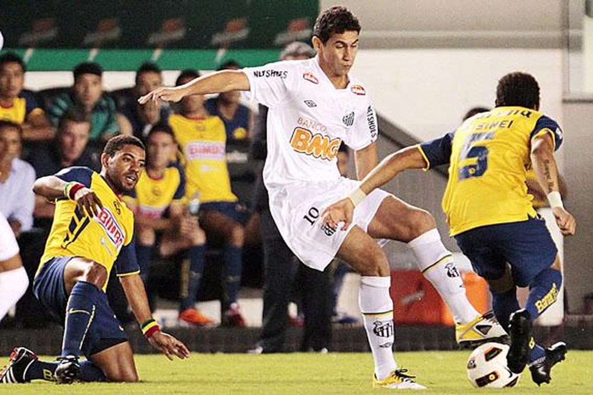 Gelandang Santos, Paulo Henrique Ganso (tengah), mengolah bola di antara dua pemain America, Olivera (kiri) dan Rosinei, pada pertandingan Piala Libertadores di Stadion Vila Belmiro, Santos, Brasil, Rabu (27/4).