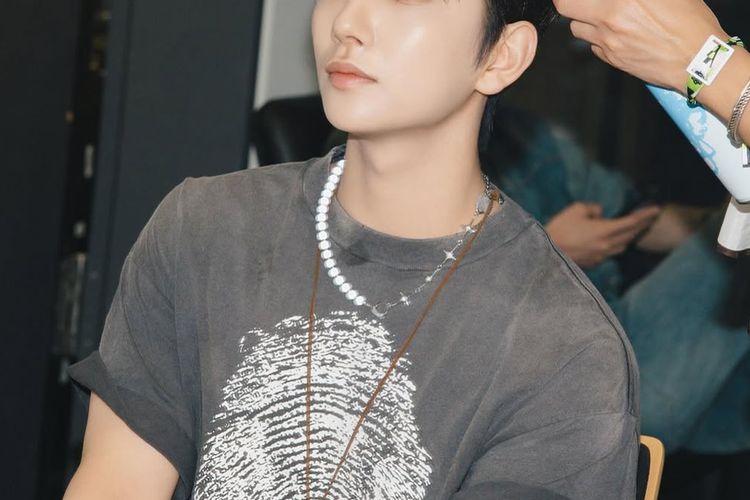 Joshua Hang mengenakan kaus abu-abu pudar.