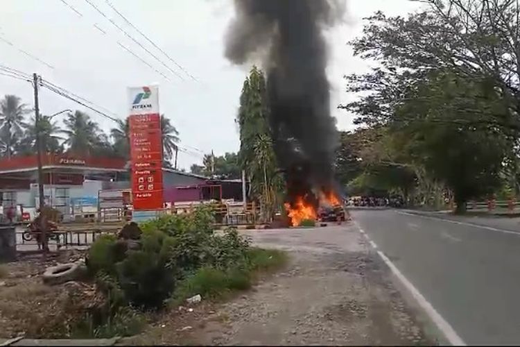 Sebuah mobil minibus hangus terbakar di depan stasiun pengisian bahan bakar umum (SPBU) Bone-Bone, Kelurahan Bone-Bone, Kecamatan Bone-Bone, Kabupaten Luwu Utara, Sulawesi Selatan, Minggu (07/4/2024).