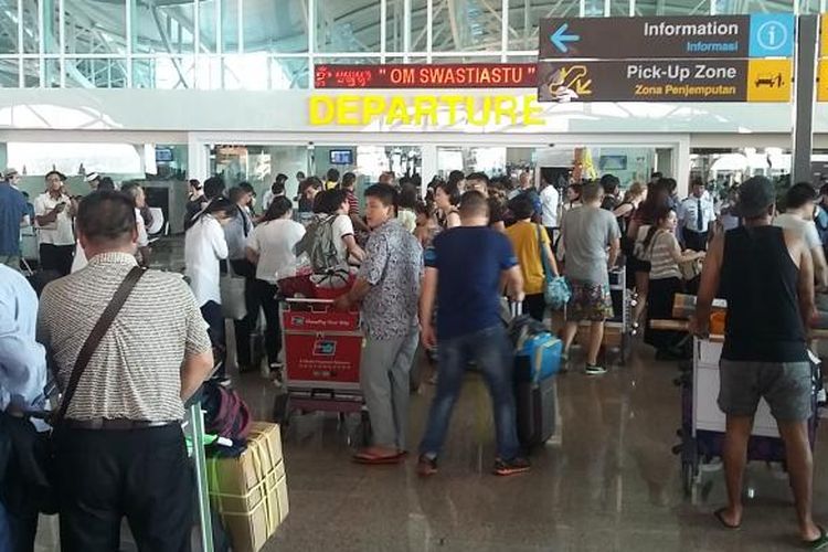 Calon penumpang sedang check in di terminal internasional Bandara Ngurah Rai. 
