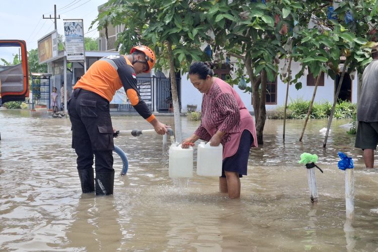 Warga terdampak banjir mengantre air bersih yang didistribusikan petugas BPBD Kabupaten Lumajang, Sabtu (25/10/2025)