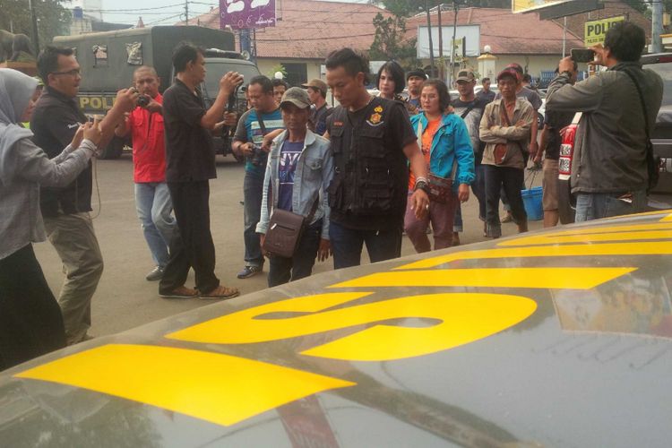 Petugas kepolisian berpakaian preman menggiring para saks dalam perkara dugaan keracunan makanan tutut di Polres Sukabumi kota, Sukabumi, Jawa Barat, Rabu (25/7/2018). 