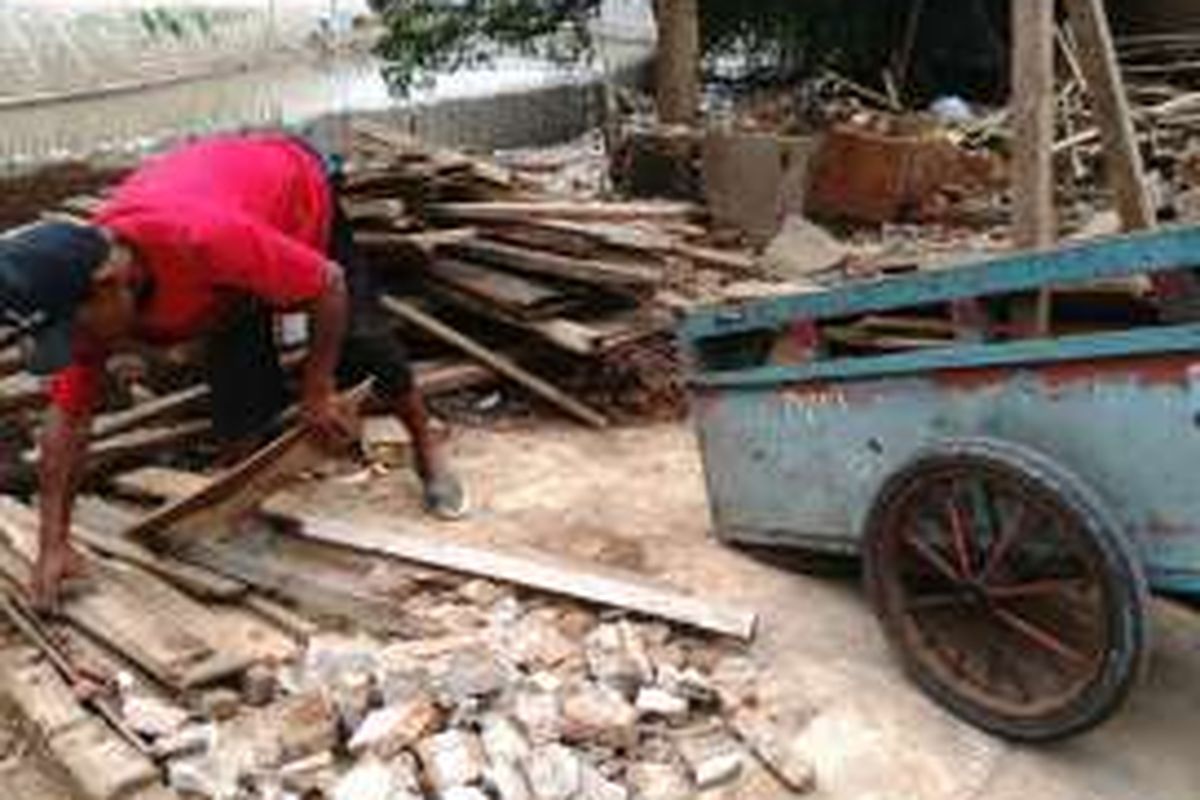 Rumawi sedang memungut sisa kayu bekas gusuran di Bukit Duri, Jakarta Selatan. Selasa (4/10/2016)