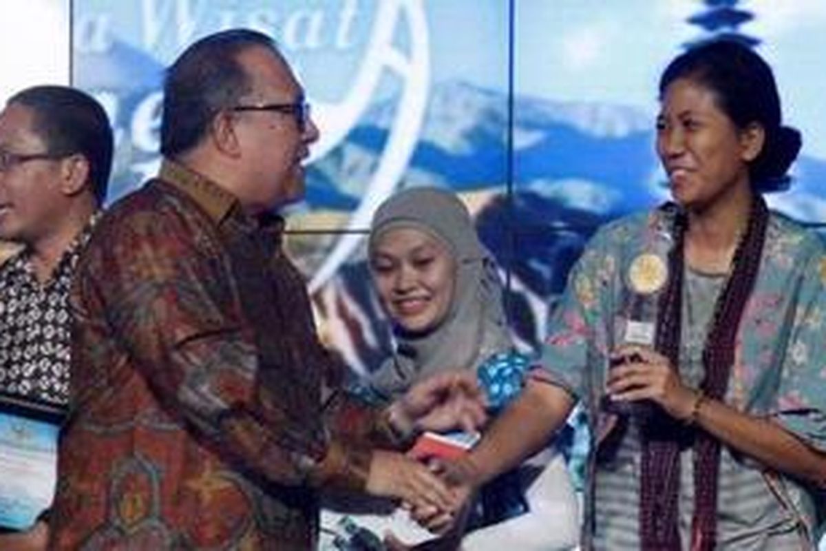Wakil Menteri Pariwisata dan Ekonomi Kreatif Sapta Nirwandar memberikan penghargaan kepada Jurnalis Kompas.com Ni Luh Made Pertiwi yang berhasil meraih penghargaan Anugerah Pewarta Wisata Indonesia (APWI) 2012 dalam acara penghargaan di Balairung Soesilo Soedarman Gedung Sapta Pesona, Jalan Medan Merdeka Barat, Jakarta, Kamis (6/12/2012). Ni Luh Made Pertiwi menjadi juara dua untuk kategori berita media on-line dengan judul karya Suka Tari Perang atau Tertarik Mengepang Rambut. KOMPAS IMAGES/RODERICK ADRIAN MOZES
