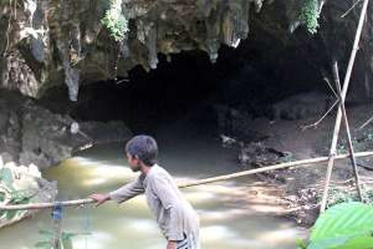 Seorang anak melewati titian kayu di depan mulut goa air, salah satu dari tiga bagian Goa Baramban di Desa Baramban, Kecamatan Piani, Kabupaten Tapin, Kalimantan Selatan, Minggu (16/10/2016). Goa Baramban merupakan goa karst terpanjang dan terbesar di Kalimantan Selatan yang terbagi menjadi tiga pecahan, yaitu goa kelelawar, goa macan, dan goa air. Goa karst nan eksotis ini masih sangat alami.