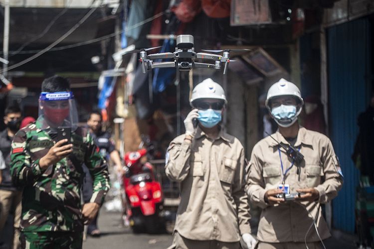 Petugas BNPB menerbangkan drone untuk melakukan pengukuran suhu tubuh warga di kawasan Pasar Tanah Abang, Jakarta, Sabtu (23/5/2020). Pengukuran suhu tubuh di kawasan tersebut bertujuan untuk pencegahan penyebaran Covid-19.