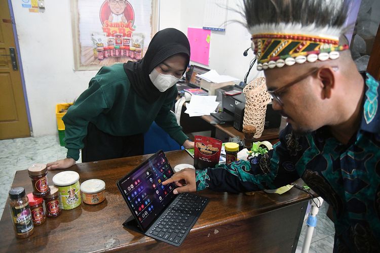 Pelaku UMKM Muhammad Yamin Rachman bersama pekerja memeriksa pesanan produk Sambal Baba melalui media sosial di Jayapura, Papua.
