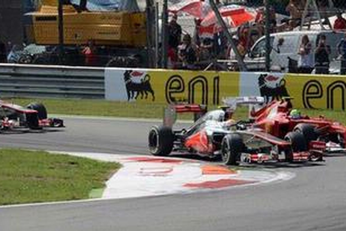 Pebalap McLaren, Lewis Hamilton (kiri), ketika bersaing dengan pebalap Ferrari, Felipe Massa, pada tikungan pertama usai start GP Italia, Minggu (9/9/2012). Hamilton memenangi balapan ini, sedangkan Massa finis di peringkat keempat.