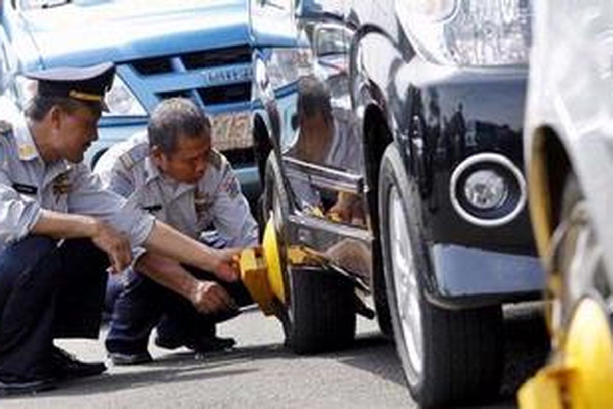 Petugas Dinas Perhubungan merazia kendaraan roda empat yang parkir di area terlarang di Jalan Salemba Raya, Jakarta Pusat, Rabu (15/12/2010). Operasi rutin yang melibatkan TNI dan Polri ini menjaring 11 kendaraan. 