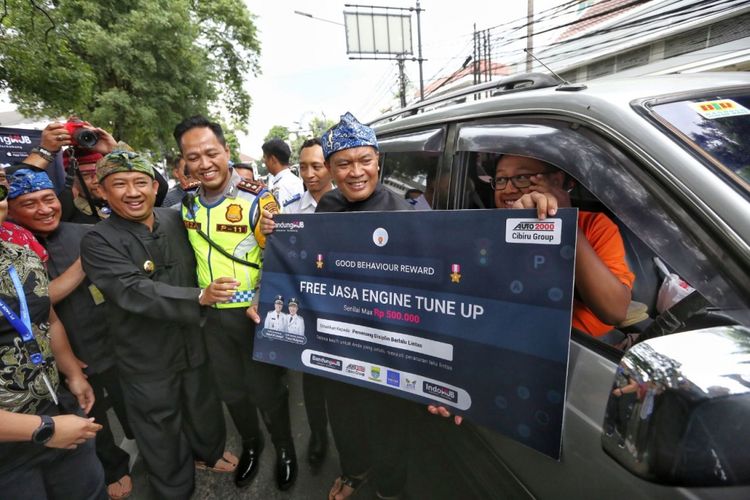 Wali Kota Bandung Oded M Danial secara simbolis menyerahkan hadiah kepada pengguna kendaraan roda empat yang tertib di persimpangan jalan, Rabu (26/12/2018).