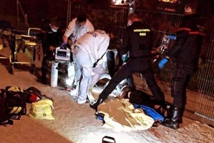 Polisi dan petugas penyelamat mengangkat dua perempyan yang menjadi korban penikaman di bawah Menara Eiffel, Paris, Perancis, pada Minggu (18/10/2020). Dua perempuan itu ditikam oleh dua wanita kulit putih, di mana mereka sempat diteriaki Arab kotor.