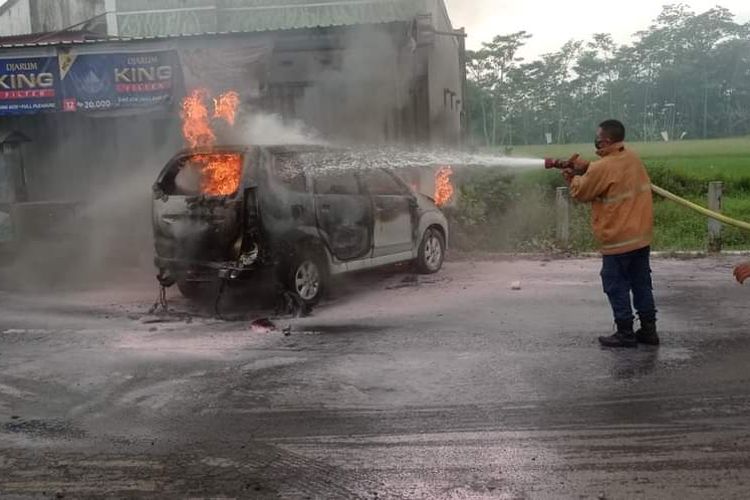 Petugas pemadam kebakaran berusaha memadamkan api yang membakar mobil, Rabu (15/2/2023).