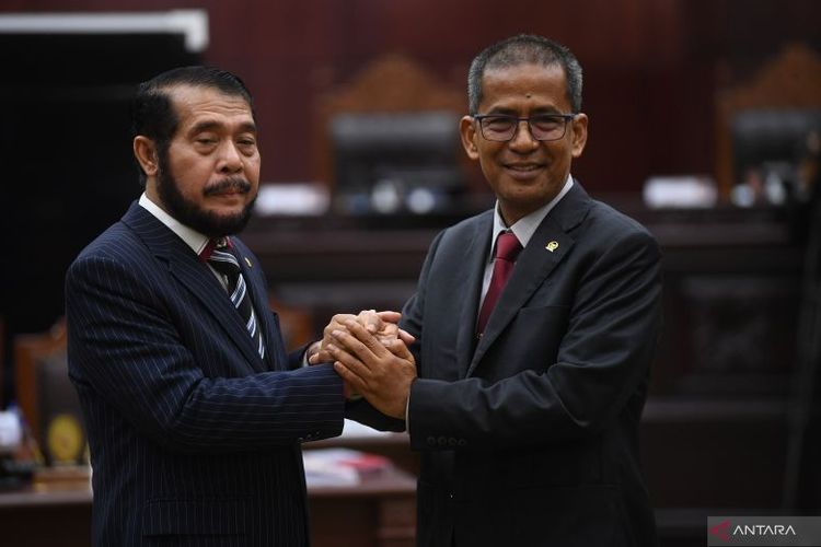 Ketua dan Wakil Ketua Mahkamah Konstitusi terpilih periode 2023-2028 Anwar Usman (kiri) dan Saldi Isra (kanan) saling berjabat tangan usai pemilihan di Gedung MK, Jakarta, Rabu (15/3/2023).