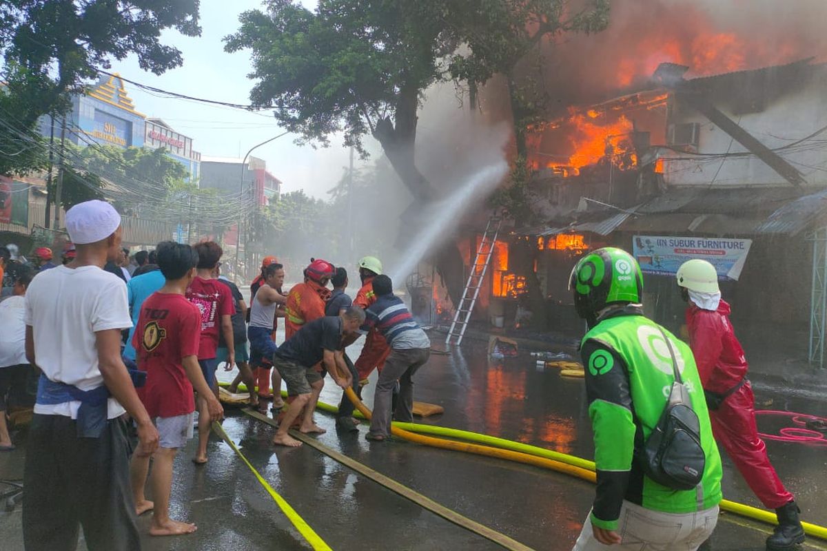 Petugas pemadam kebakaran bersama warga memadamkan api yang membakar 40 rumah di Jalan Payakumbuh RT. 07 RW. 09 Kelurahan Pasar Manggis, Setiabudi, Jakarta, Selasa (7/7/2020).
