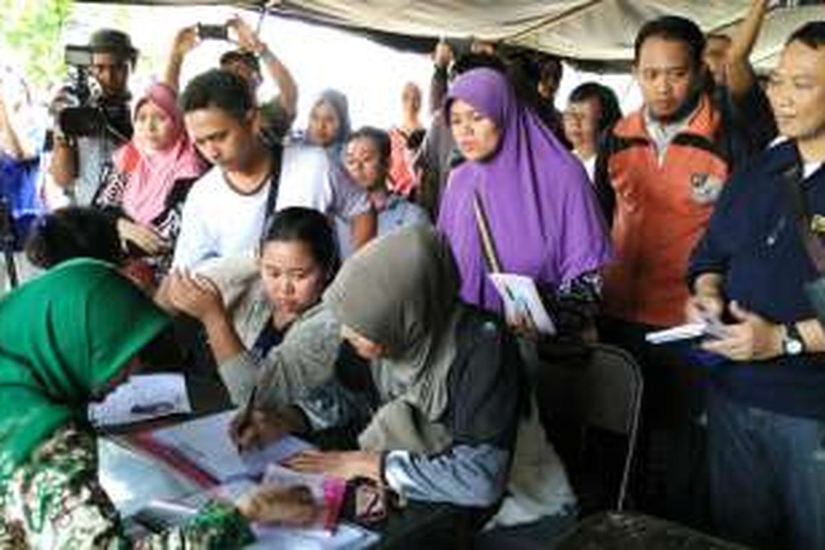 Orangtua yang memvaksinkan anaknya di RS Harapan Bunda mengerumuni para petugas posko pengaduan saat mereka baru tiba di posko sekitar pukul 10.00, Minggu (17/7/2016).