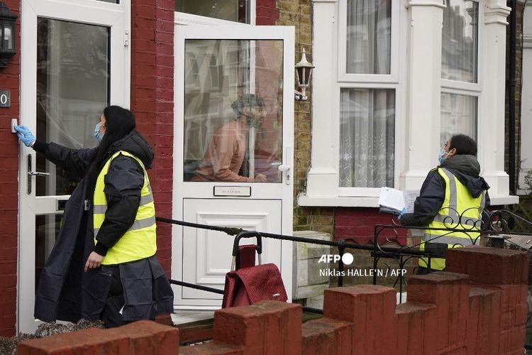 Relawan mengirimkan langsung alat uji Covid-19 ke rumah-rumah di Ealing, London barat, pada Rabu (3/2/2021). 
