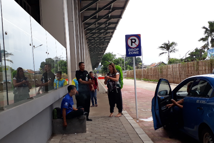 Petugas sekuriti Stasiun Sudirman Baru, memberi pejelasan kepada seorang warga negara Belanda, Maiike, Rabu (7/2/2018), bahwa kereta bandara Soekarno-Hatta tidak beroperasi sementara dan stasiun ditutup.
