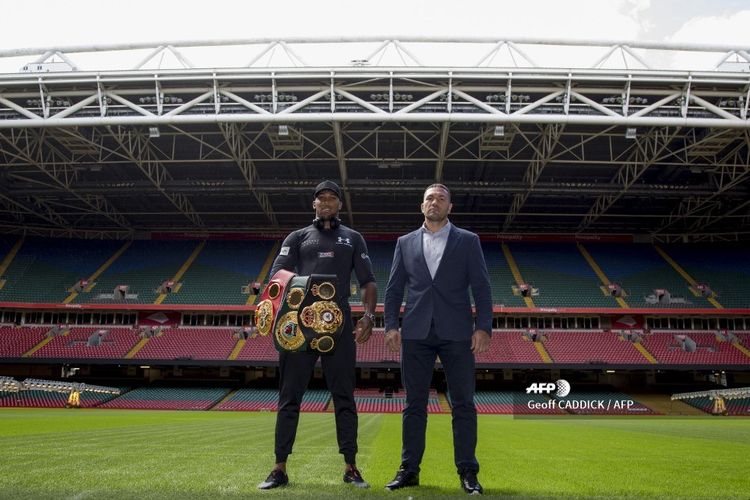 Britains Anthony Joshua (L) and Bulgarias Kubrat Pulev (R) stand on the pitch at the Principality Stadium in Cardiff on September 11, 2017 during a promotional event for their heavyweight world title boxing match. 