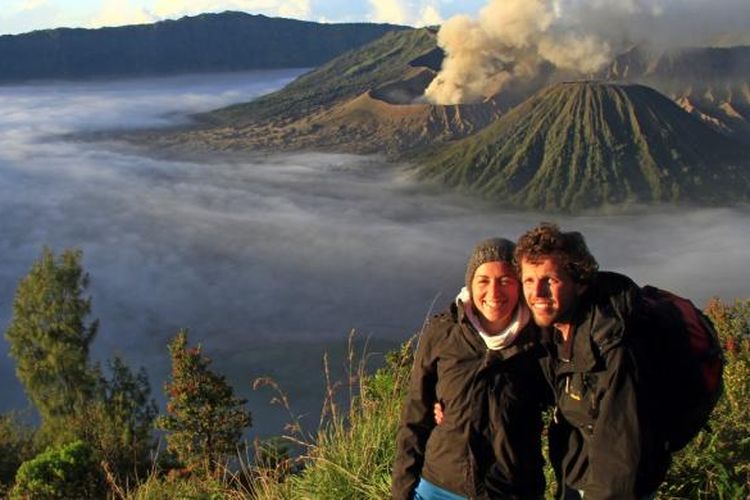 Sepasang turis asing berfoto dengan latar belakang Gunung Bromo dan Gunung Batok di Bukit Kingkong.