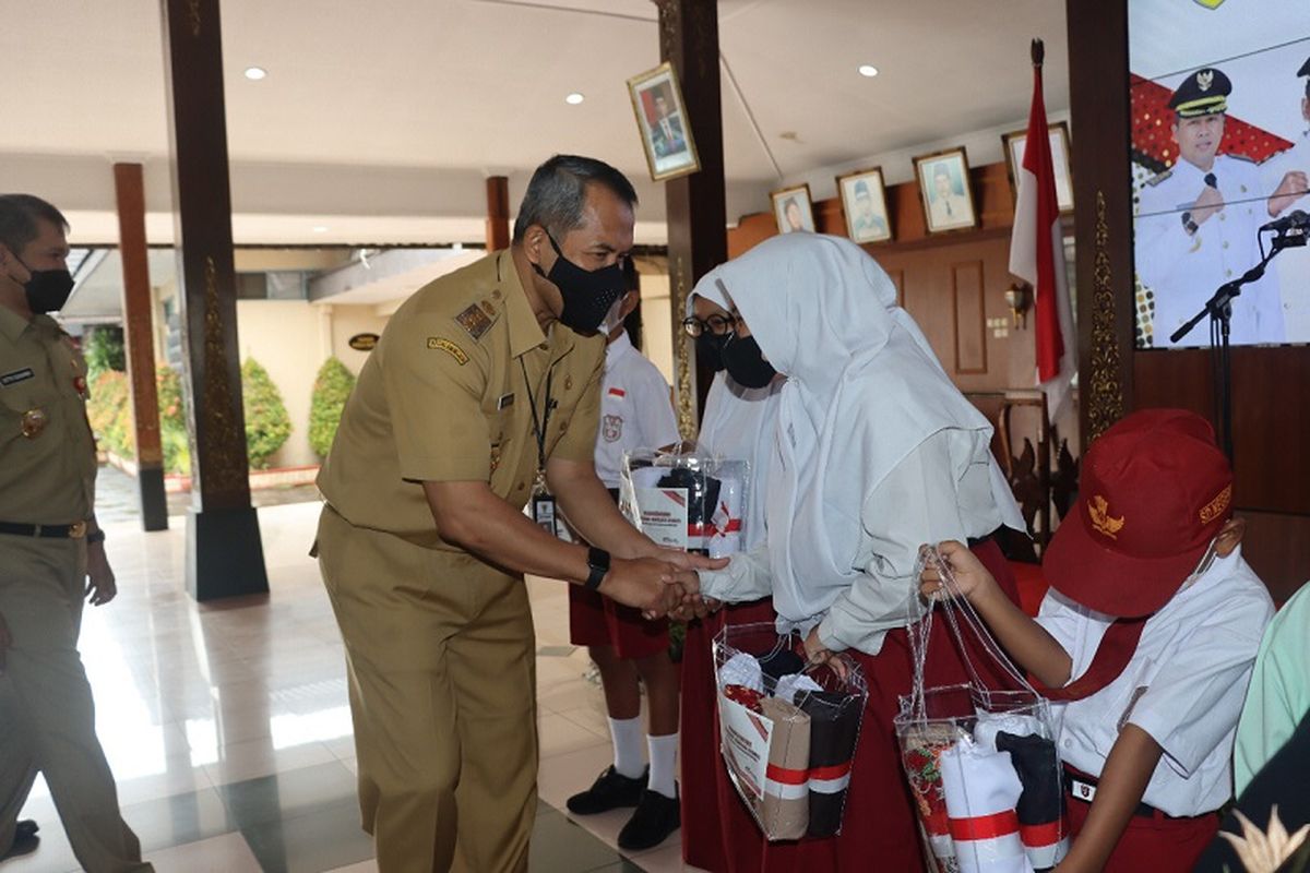Bupati Wonogiri Joko Sutopo secara simbolis menyerahkan seragam gratis bagi siswa SD/MI dan SMP/MTS di Pendopo Pemkab Wonogiri, Selasa (19/10/2022).