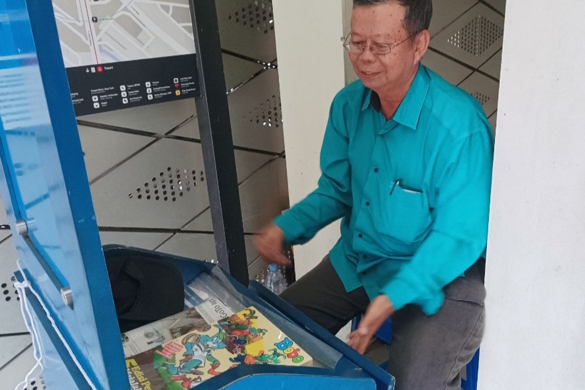 Mushoddiq saat menata lapak koran dan majalah miliknya di Halte Transjakarta Bundaran HI, Jakarta Pusat, Selasa (25/11/2025).